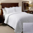 White textured bed set. Hotel bed showcases a king bed with big fluffy pillows and large oversized duvet.