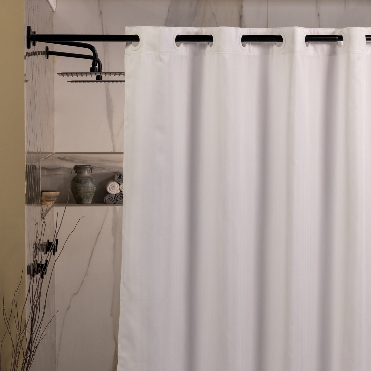 White shower curtain with black hooks in a bathroom setting