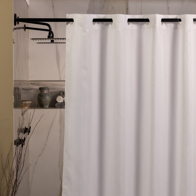 White shower curtain with black hooks in a bathroom setting