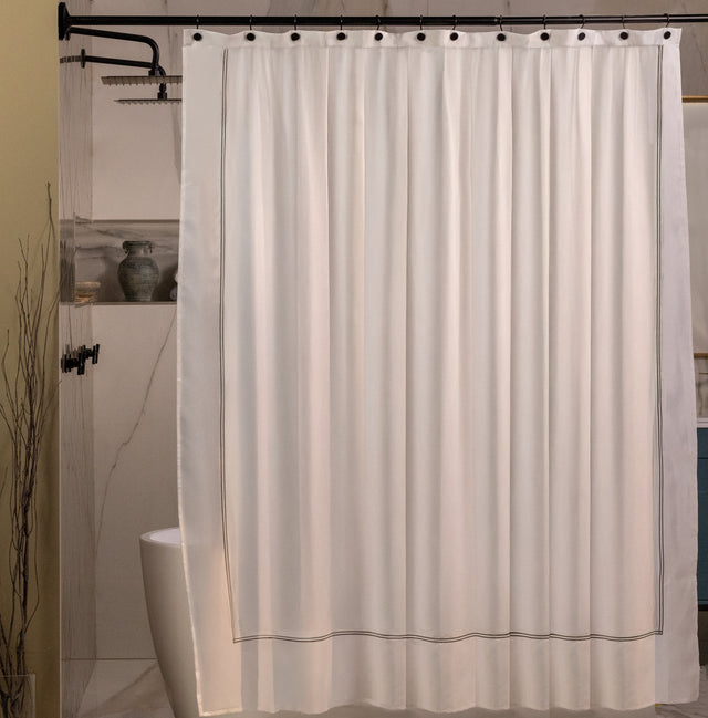 Beige shower curtain with black trim in a bathroom setting