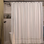 Beige shower curtain with black trim in a bathroom setting