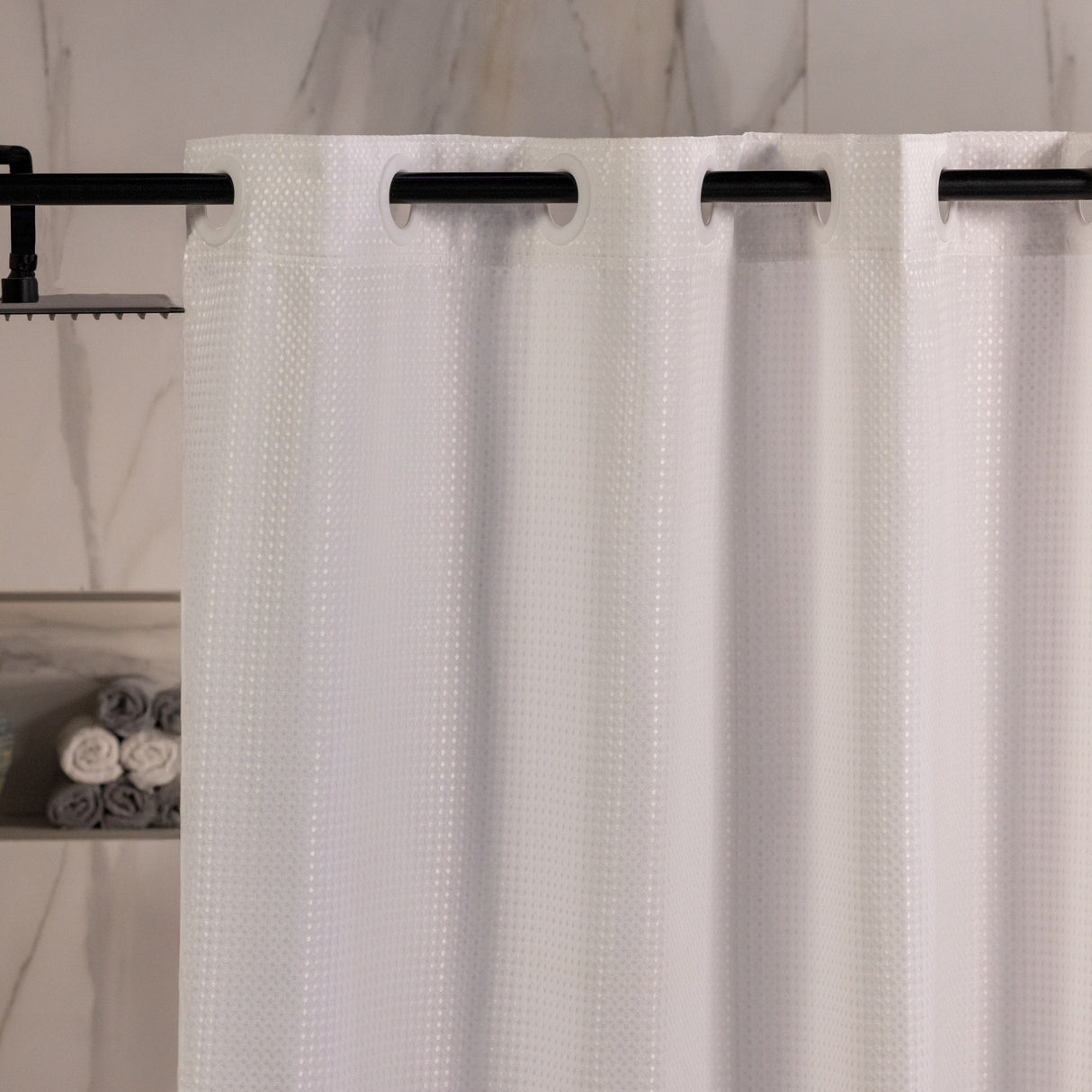 White textured shower curtain with black grommets in a bathroom setting