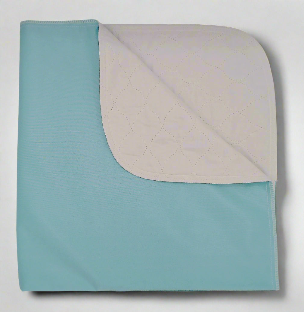 A folded reusable underpad with a twill weave pattern on the top layer and a solid color on the bottom layer, presumably with a moisture-absorbing core.
