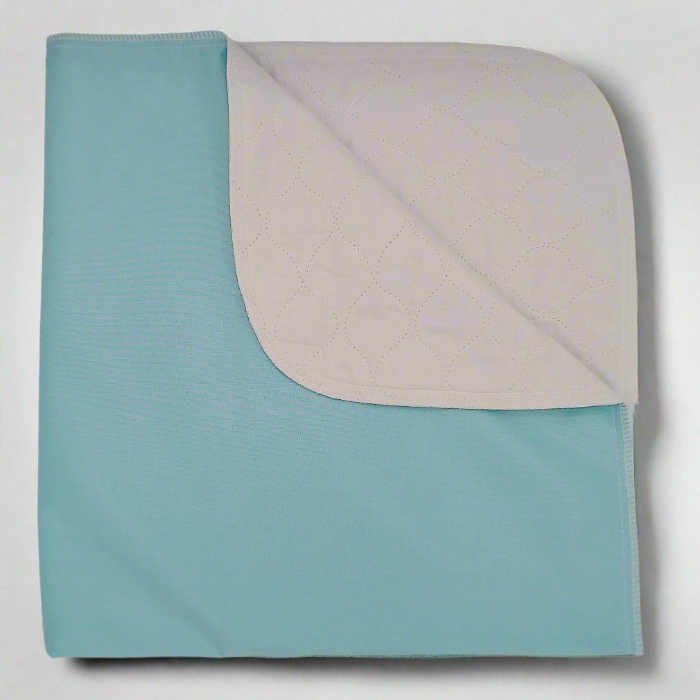 Pictured: A folded reusable underpad with a twill weave pattern on the top layer and a solid color on the bottom layer for absorbency against a white background.