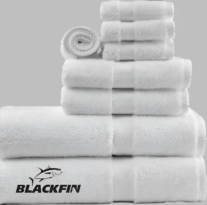 Product showcases Blackfin by Boston Textile Co. A selection of hotel towels for wholesale supply. White in color. Product is neatly rolled and placed from size of wash cloths, to hand towels to bath towels.