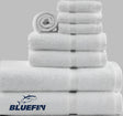 Product showcases variety of towels from the Bluefin collection by Boston Textile Co. Products are neatly rolled in order of size from wash cloths to hand towels to bath towels.