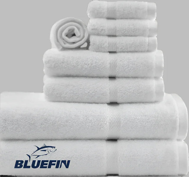 Product showcases variety of towels from the Bluefin collection by Boston Textile Co. Products are neatly rolled in order of size from wash cloths to hand towels to bath towels.