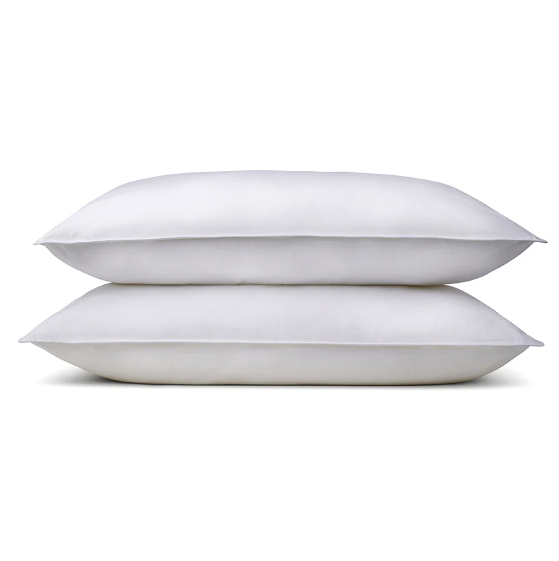 Two white, plush pillows stacked on top of each other against a white background.