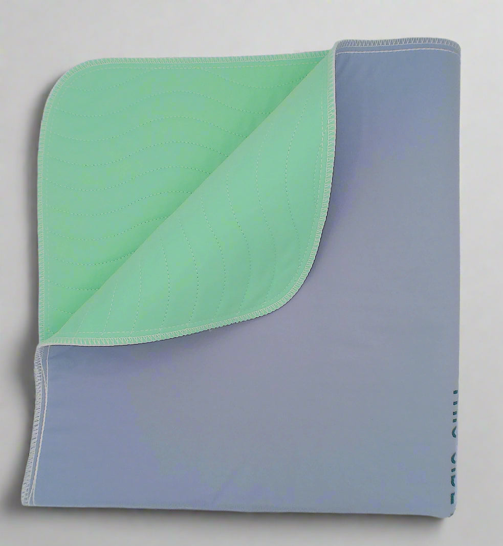 A folded DryTouch Ultra Absorbent Underpad showing a light green top layer and gray backing.
