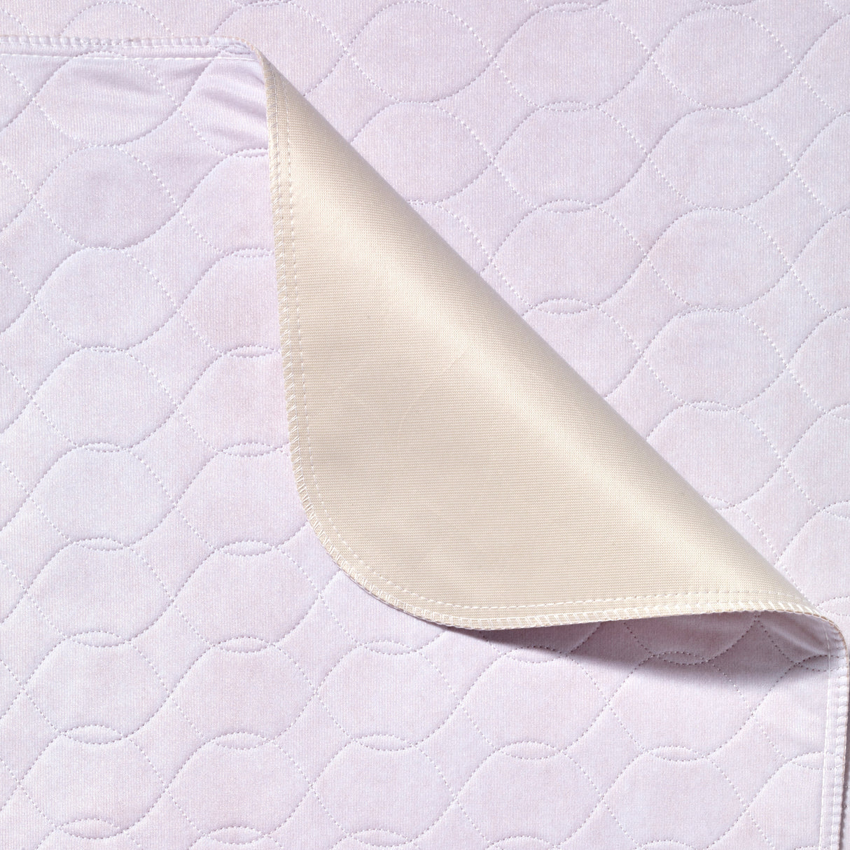 White quilted fabric with a folded corner on a matching background