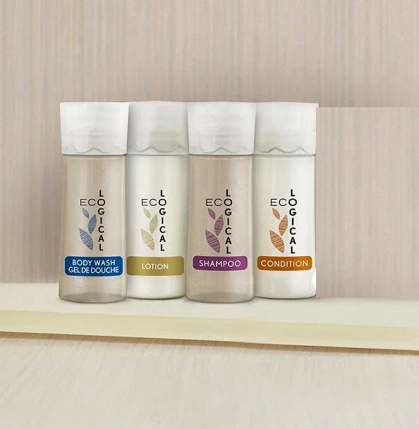 Hotel Amenity collection by Eco Logical. Product showcases full collection from left to right; body wash, lotion, shampoo, conditioner. Product on wooden shelf with a wooden wall background.