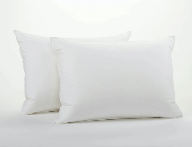 Two white pillows with a knife edge finish on a white background.