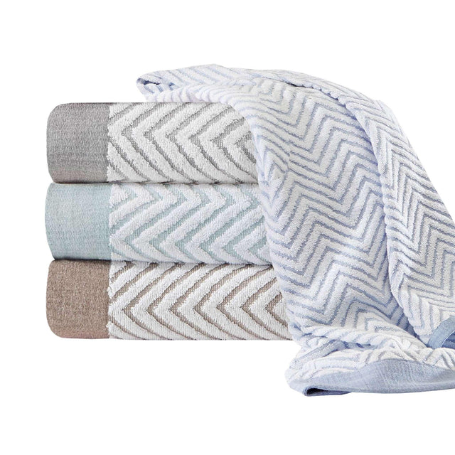 Product photoshoot of multiple hotel linen towels folded on top of eachother in a variety of colors. White background.