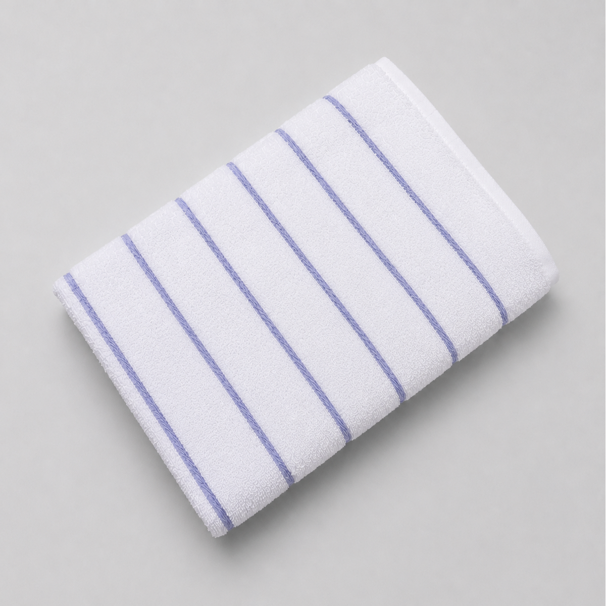 Pictured: Fibertone Twill Striped Pool Towel neatly folded against a white background. The stripes are colored and listed under the shade "Porcelain".