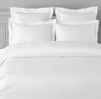 A white duvet cover displayed on a bed, with pillows covered in a matching white pillowcase.