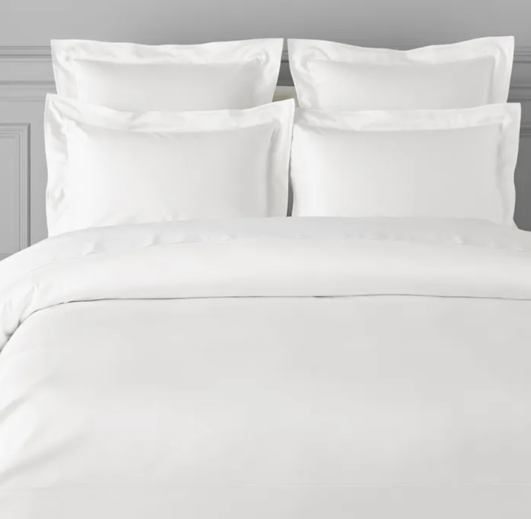 A white duvet cover displayed on a bed, with pillows covered in a matching white pillowcase.