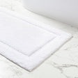 White bath mat on a marble floor