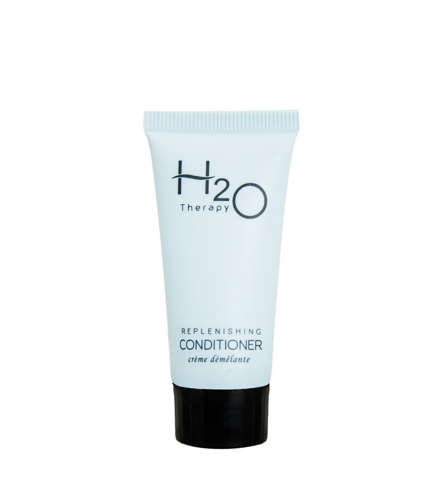Product shot of H2O Therapy sample size hotel amenity replenishing conditioner with off blue color. White background.