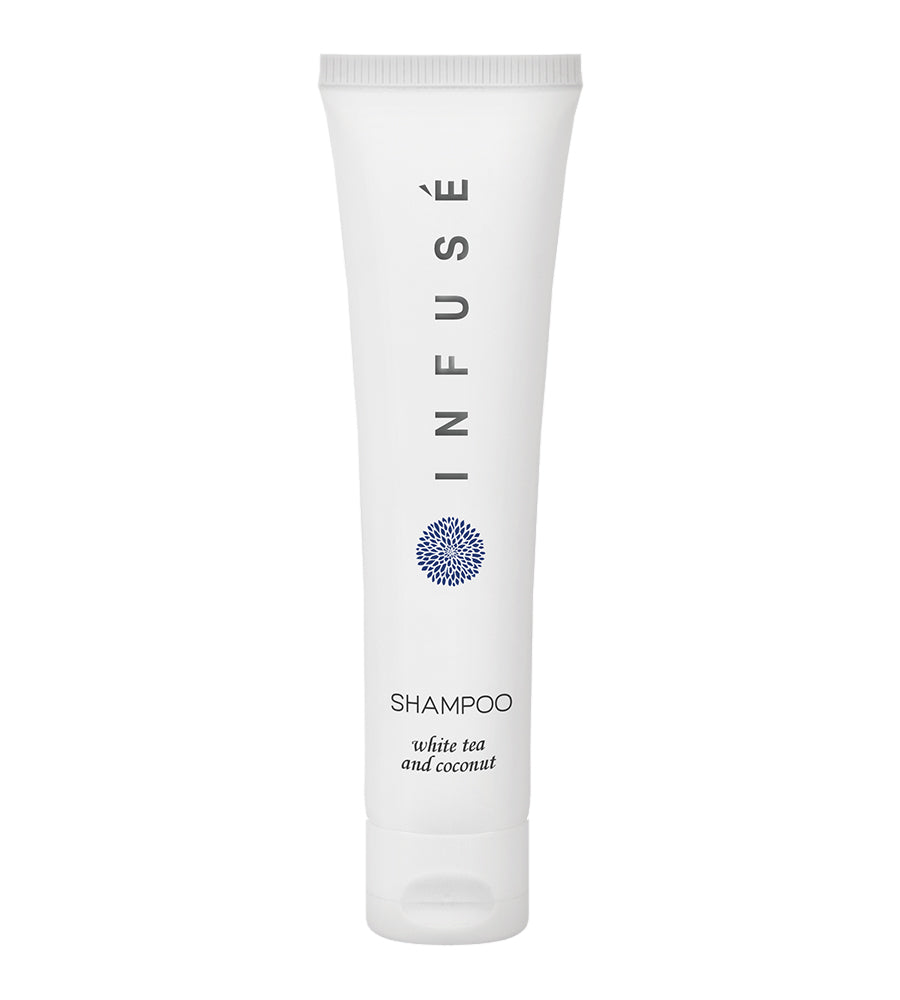 Product shot of infuse white hotel amenity collection shampoo with white tea and coconut. White background.