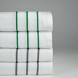 Stack of white pool towels with green and grey stripes