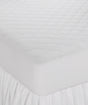 A white, fitted Martex Ultra Touch Mattress Pad on a bed, showcasing its quilted design and fitted skirt.