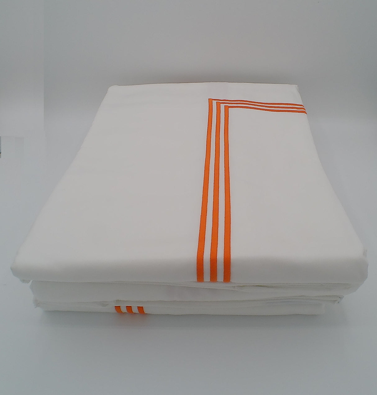 White folded towel with orange stripes on a white background
