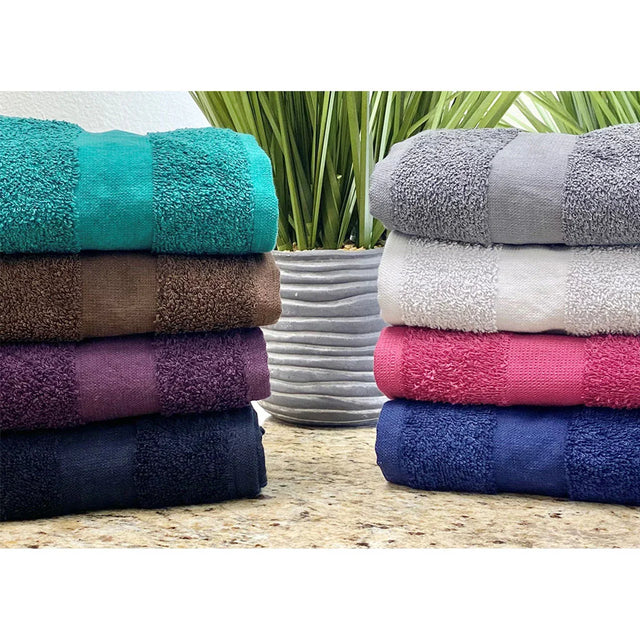 Stacks of folded salon towels in various solid colors including green, brown, gray, pink, blue, and purple, displayed on a marble surface.