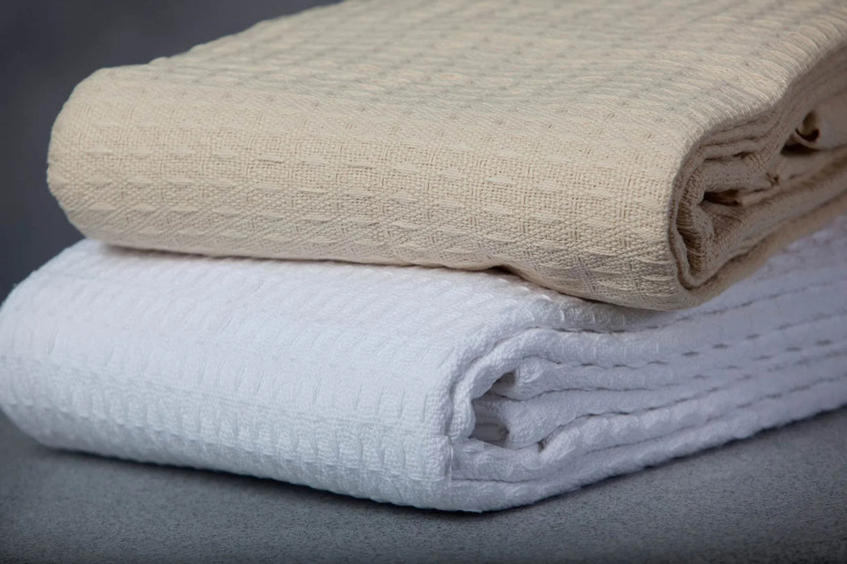 product shot of textured waffle cotton blankets in white and beige colors.