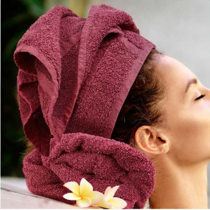 Person with a burgundy towel wrapped around their head, with a blurred background