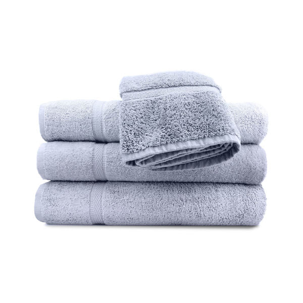 A set of beige pool towels stacked neatly, with a classic dobby border.