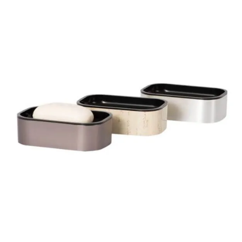 Pictured: Three Rectangular Soap Dishes against a white background. The one on the left is in the shade "Graphite" and is holding a white bar of soap. We do not carry the dish in the middle. The dish on the right is in the shade "Silver". All of the insides of these dishes are black.