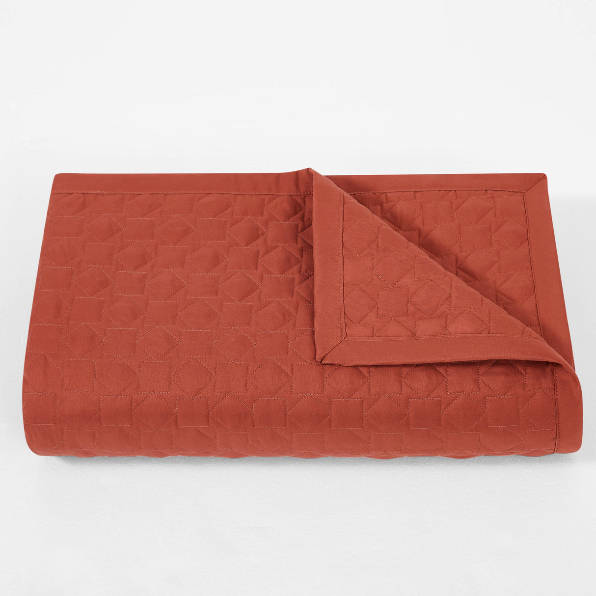 Quilted brown blanket on a white background