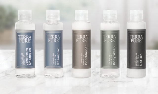 Terra pure full sample product display reading from left to right; conditioning shampoo, shampoo, conditioner, body wash and lotion. All displayed on a marble countertop in a bright lit room.