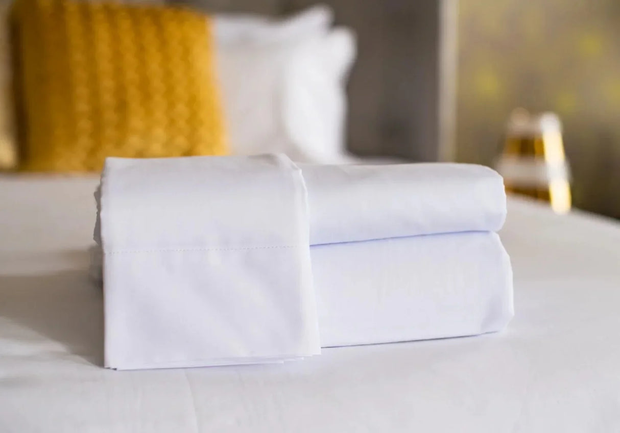 Neatly folded bed sheets with high quality linen. Features pillow cases, fitted sheets and flat sheets.