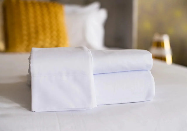 Neatly folded bed sheets with high quality linen. Features pillow cases, fitted sheets and flat sheets.