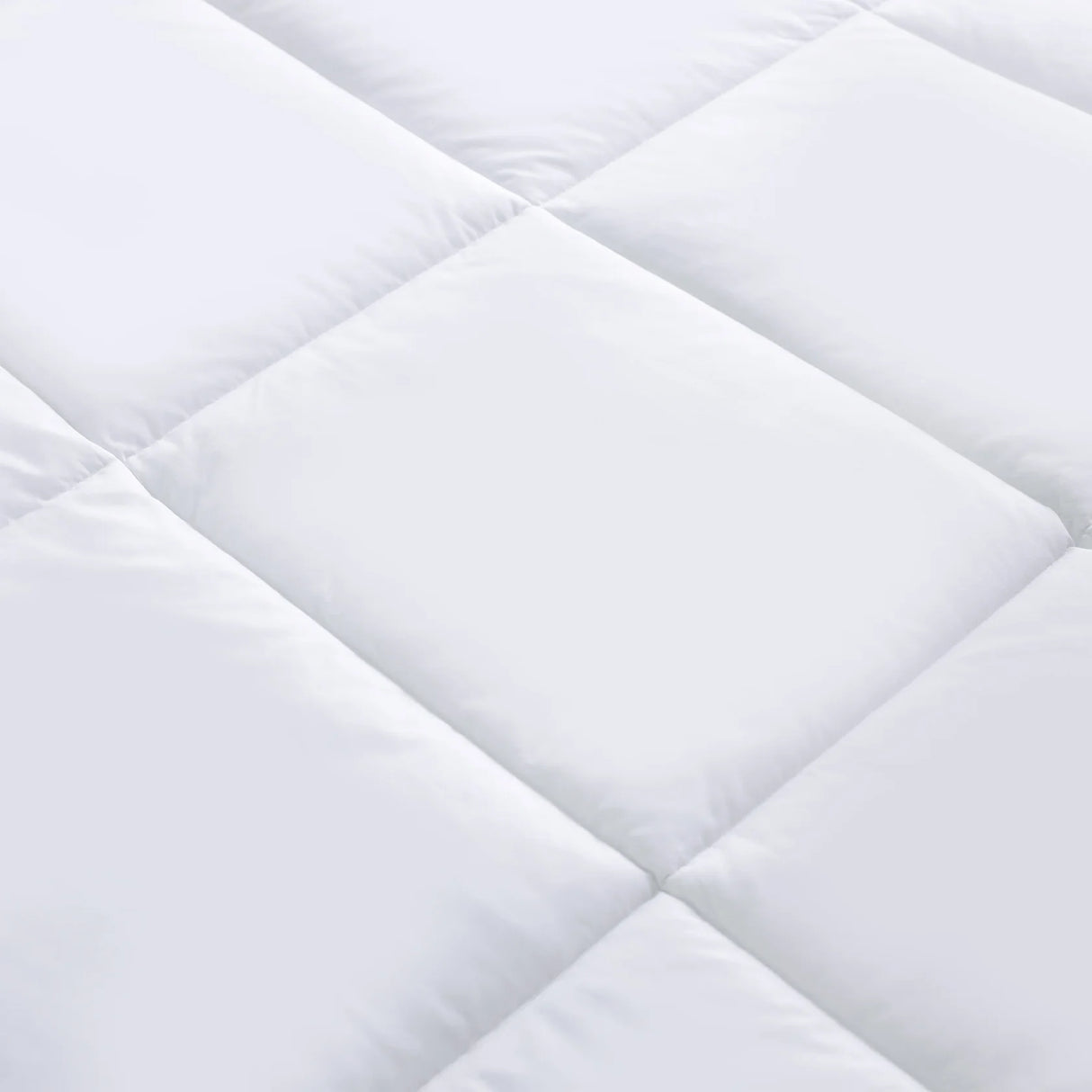 Close-up of a white quilted fabric with diamond pattern