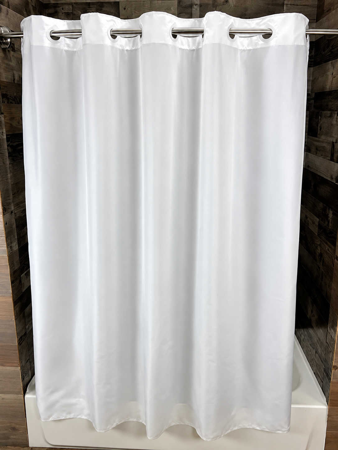Pictured: The white nylon Hang2It Hotel Shower Curtain hanging on a silver rod in front of a bathtub.