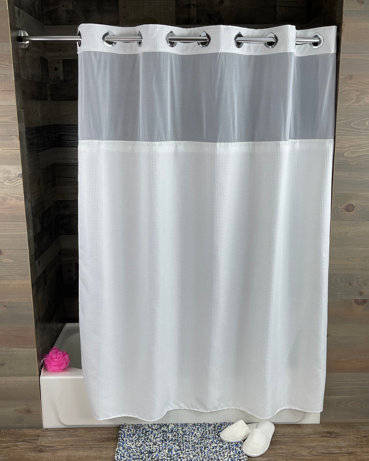 Pictured: White Hang2It Waffle Shower Curtain hanging on silver rod in front of a white tub.