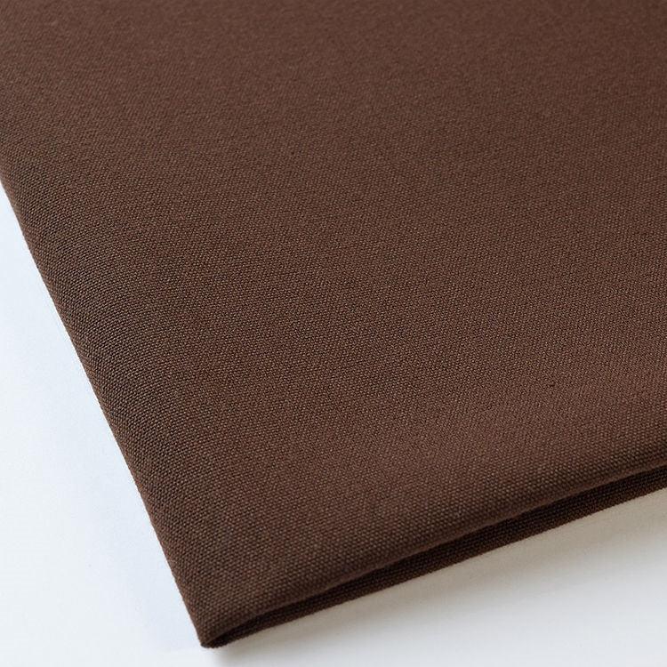 Pictured: Close up of the Premier Napkin neatly folded in the shade Brown against a white background.