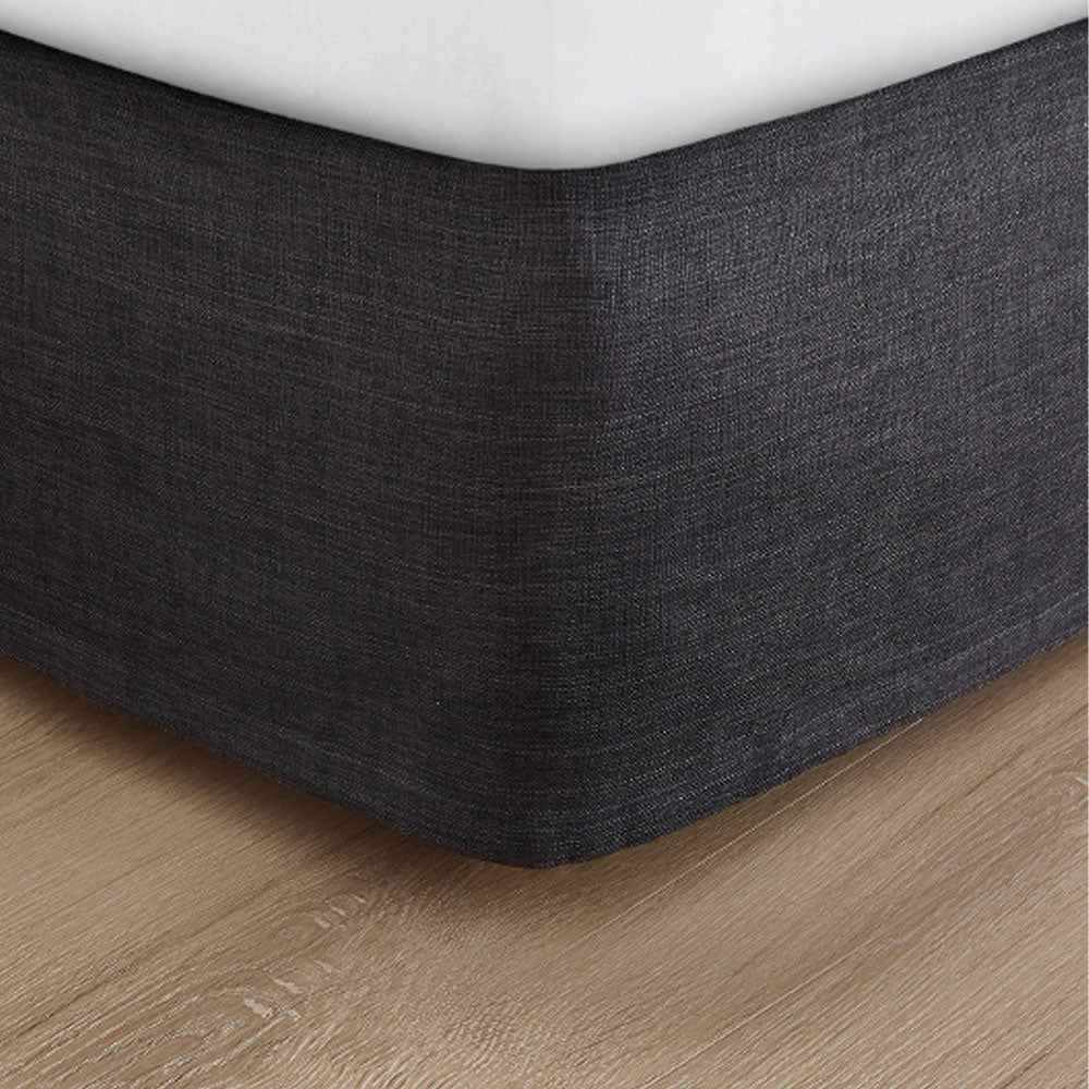 Pictured: Dark grey bed skirt under a white mattress.