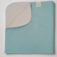 Pictured: A green premium twill underpad with a white leakproof barrier and a tag visible on the upper corner. The underpad lies against a white background.