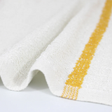 White towel with a yellow stripe on a light gray background