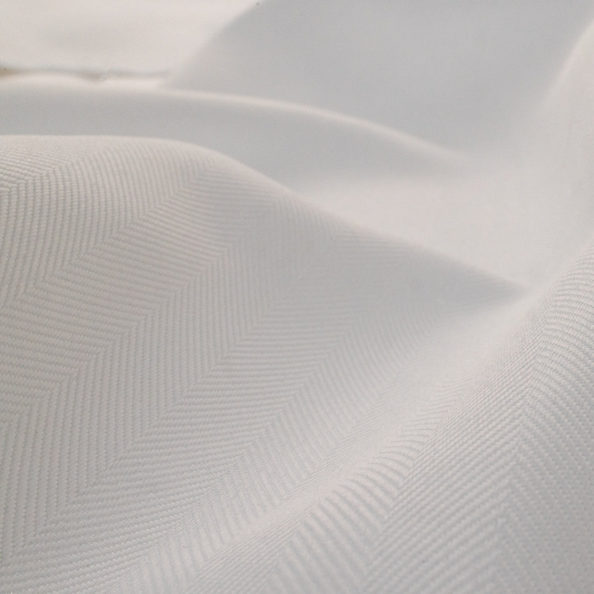 Close-up of textured white fabric with a subtle pattern