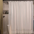 Pictured: Modern bathroom with a free standing tub in a large standing shower. On the curtain rod is the Embroidered Shower Curtain, which is white with taupe embroidering.