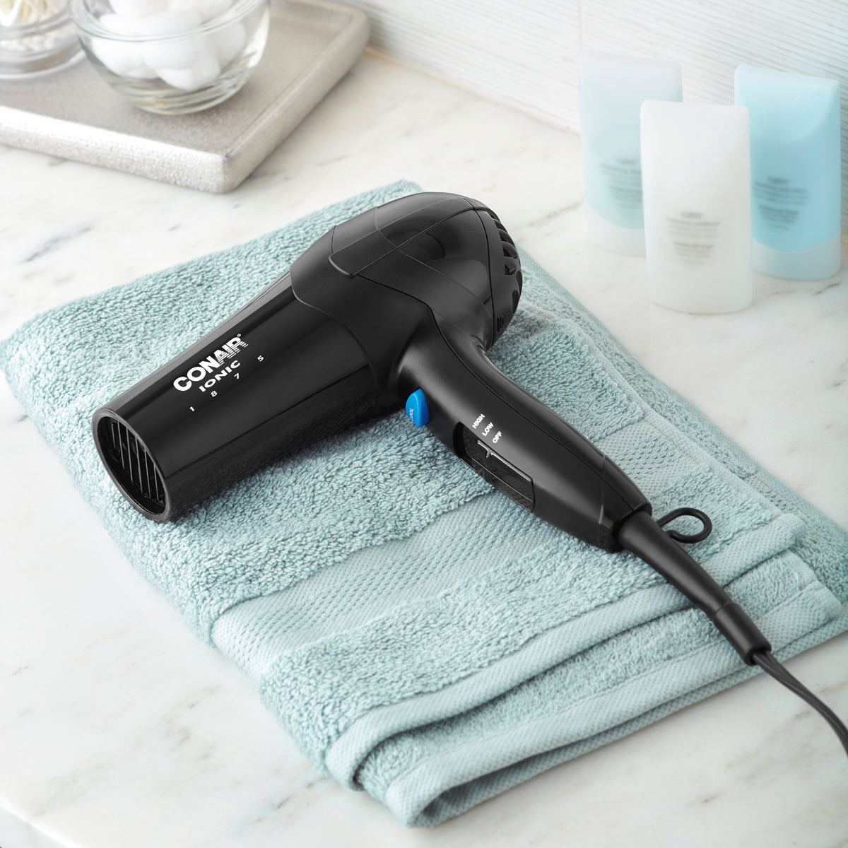 Black hair dryer on a light blue towel with a white background