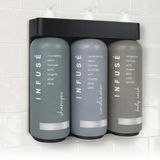 Three gray bottles labeled 'Infuse' on a white tiled wall.