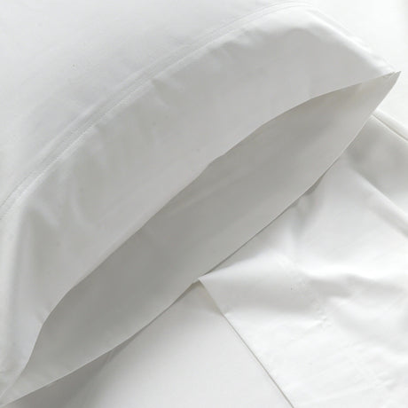 Close-up of white bedding fabric with a pillow