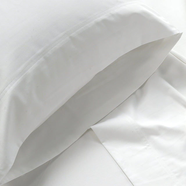 Close-up of white bedding fabric with a pillow