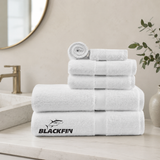 Stack of white towels with Blackfin logo on a bathroom counter