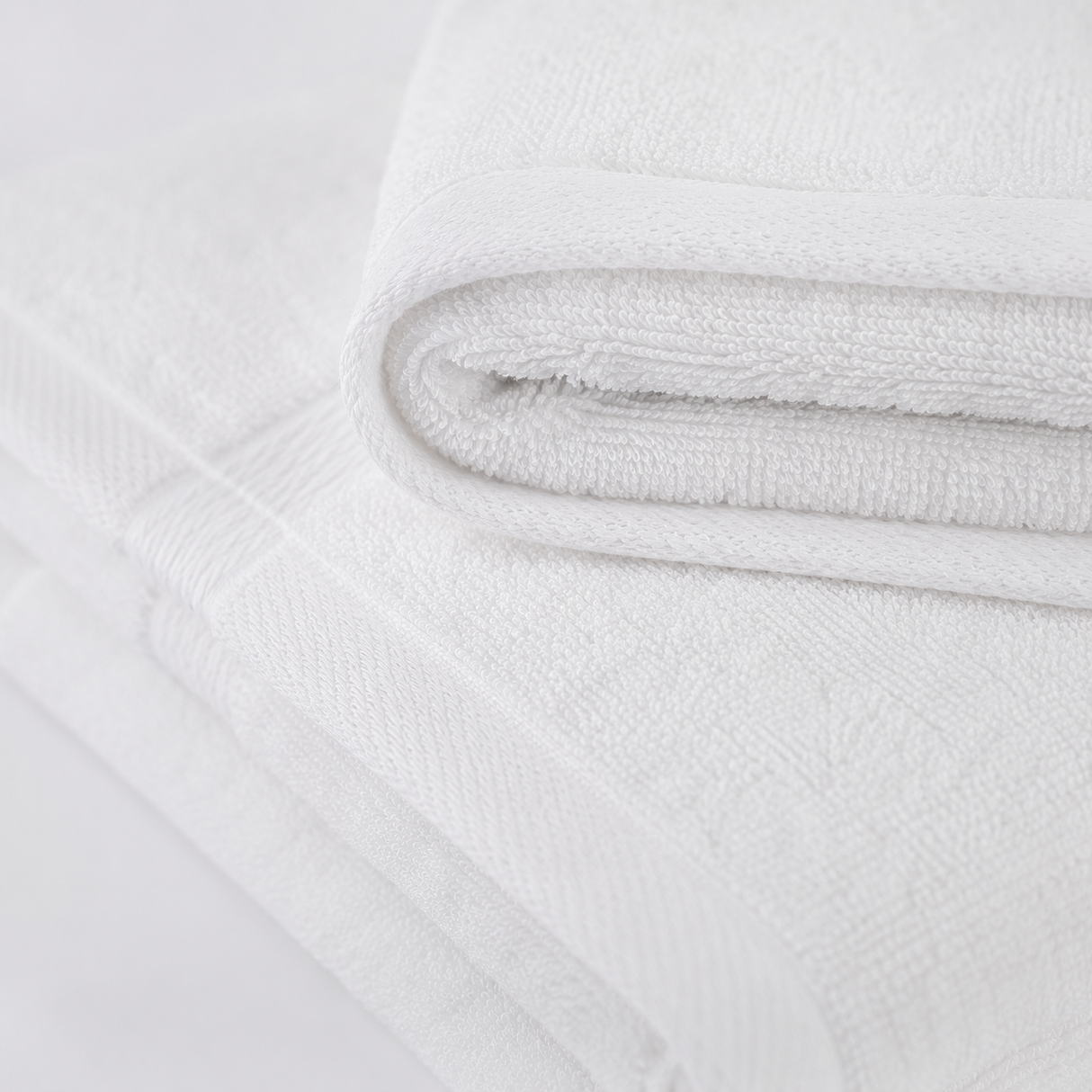Close-up of a textured white fabric with a subtle pattern on a light gray background